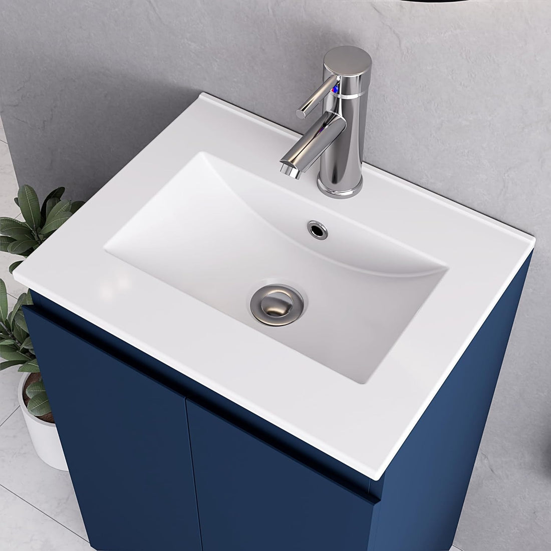 Close-up of white integrated sink with chrome faucet on 500mm dark blue vanity unit